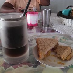 A picture of Leftover veg sandwhich with iced coffee.