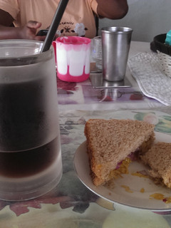 A picture of Leftover veg sandwhich with iced coffee.
