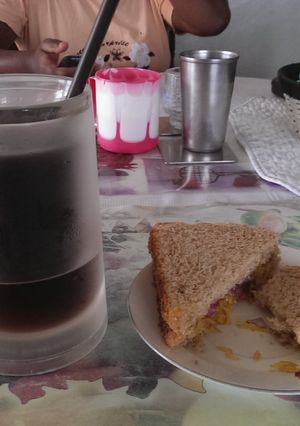 A picture of Leftover veg sandwhich with iced coffee.