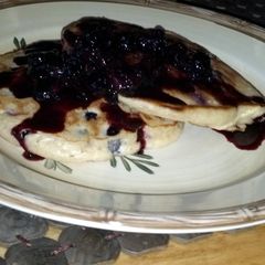 A picture of Blueberry pancakes with blueberry molasses syrup.