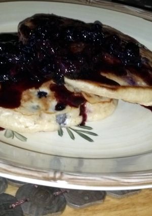 A picture of Blueberry pancakes with blueberry molasses syrup.