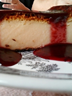 A picture of Cheescake & raspberry sauce.