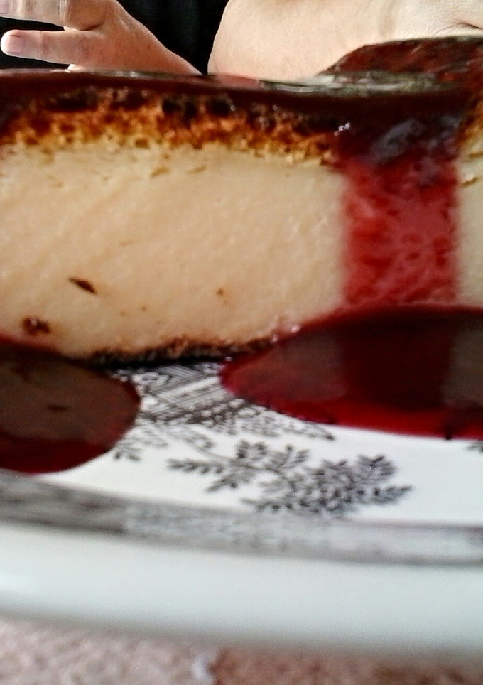A picture of Cheescake & raspberry sauce.