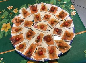 Une photo de Canapés de saumon fumé,crème,aneth et tomates sur pain polaire
