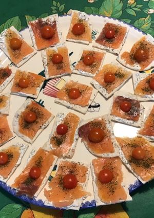 Une photo de Canapés de saumon fumé,crème,aneth et tomates sur pain polaire