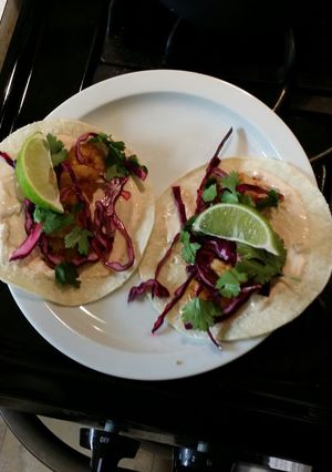 A picture of Shrimp tacos with red cabbage lime slaw.