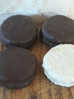 Una foto de Alfajores de coco bañados de chocolate blanco/negro