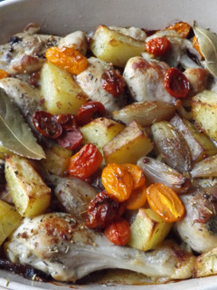 Una foto de Muslitos de pollo con mix de tomatitos y chalotas al horno