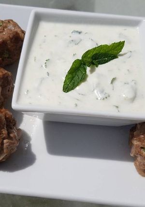 A picture of Spicy lamb meatballs with a tangy yoghurt sauce.