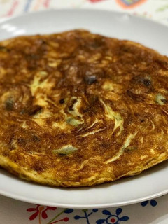 Una foto de Tortilla de patata con calabacín y ajos tiernos
