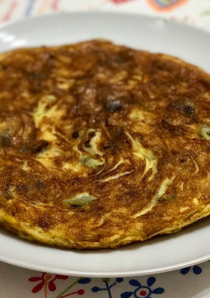 Una foto de Tortilla de patata con calabacín y ajos tiernos