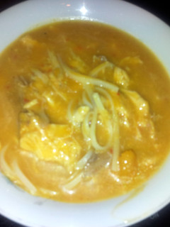 A picture of thai chicken, butternut squash and noodle soup.