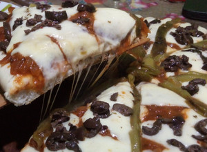 Una foto de Pizza de muzzarella con morrón verde y aceitunas negras