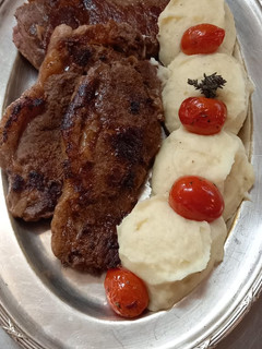 Una foto de Bifes con puré de papas y tomates Cherry