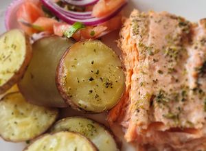 Una foto de Salmón a la limonada con papas rústicas y ensalada a la chilena