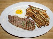 Una foto de bistec con huevo frito
