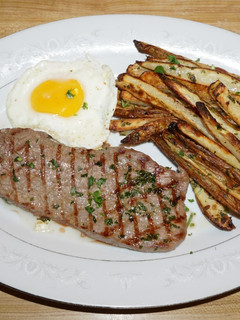 Una foto de BISTEC CON HUEVO FRITO Y PAPAS HORNEADAS CON CHAQUETA. JON STYLE