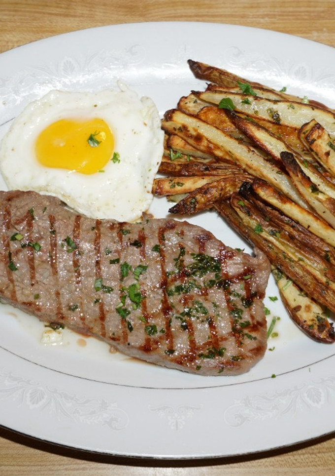 Una foto de BISTEC CON HUEVO FRITO Y PAPAS HORNEADAS CON CHAQUETA. JON STYLE