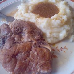 A picture of Crockpot pork chops with brown gravy.