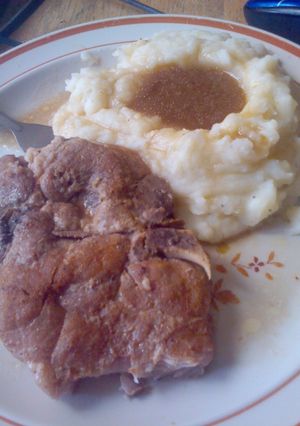 A picture of Crockpot pork chops with brown gravy.