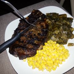 A picture of Lebanese spiced rib eye with collards and sweet&spicy corn.