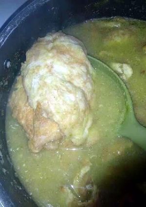 A picture of Tortitas de pollo en salsa Verde (Chicken in egg batter and green salsa).