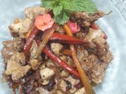 Una foto de pollo salteado con cebolla y pimiento