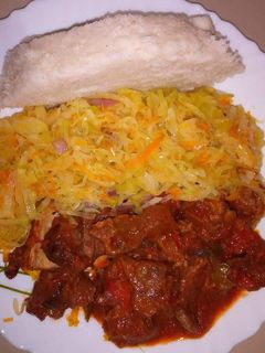 A picture of Wet fried beef, cabbage with Ugali.