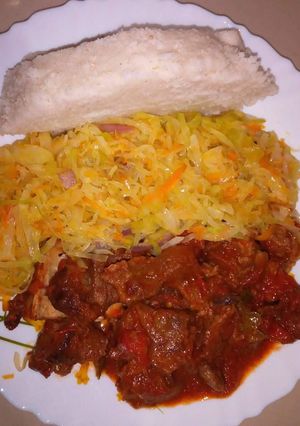A picture of Wet fried beef, cabbage with Ugali.