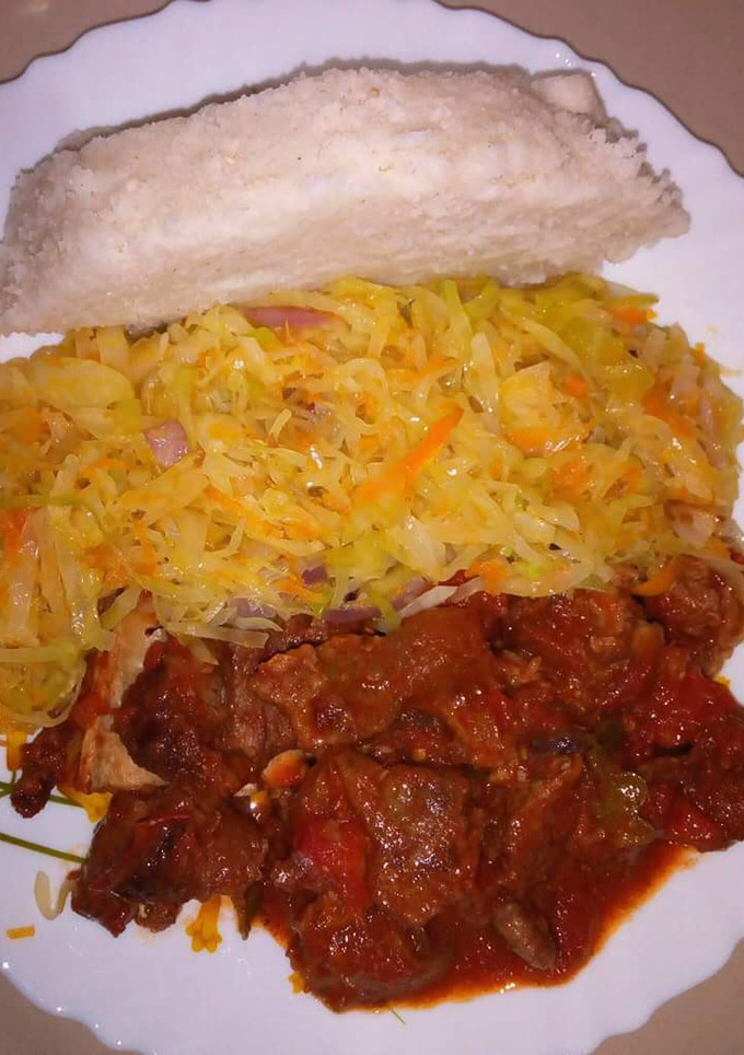 A picture of Wet fried beef, cabbage with Ugali.