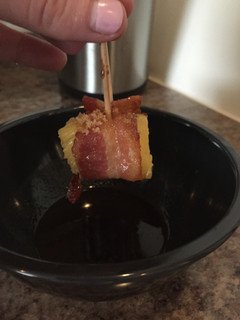 A picture of Candied Bacon-Wrapped Pineapple With Honey Sriracha Sauce.