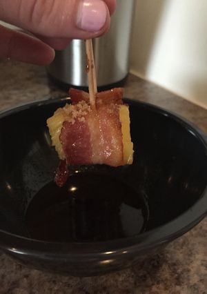 A picture of Candied Bacon-Wrapped Pineapple With Honey Sriracha Sauce.