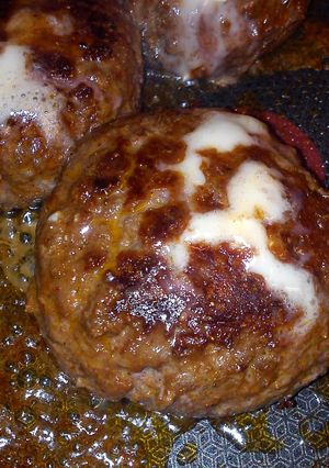 A picture of home made spicy burger with cheese centre.