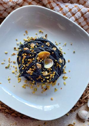 A picture of Spaghetti with Squid Ink, Clams, and Pistachios.
