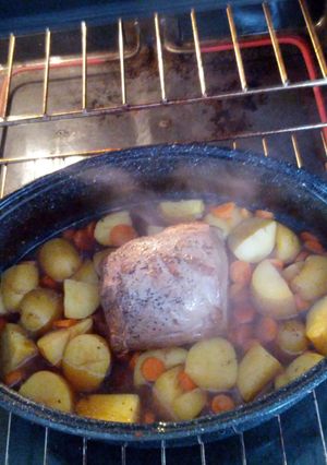 A picture of Roast beef with yellow potatoes and carrots.