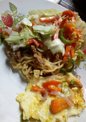 A picture of Cabbage plated noodles with veggies and egg.