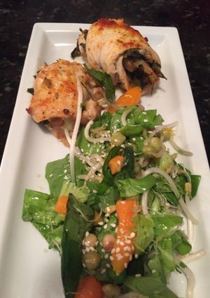 Una foto de Involtini de pollo de espinaca y nueces con ensalada de brotes
