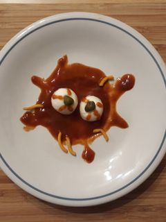 Una foto de Ojos de serpiente en salsa sangrienta con gusanos