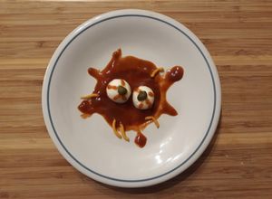 Una foto de Ojos de serpiente en salsa sangrienta con gusanos