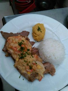 Una foto de Bistec con salsa cremosa de vegetales y puré de plátano