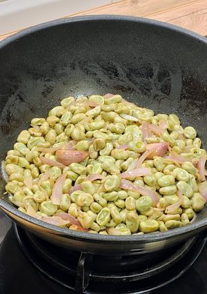 Una foto de Wok de habitas tiernas encebolladas al limón