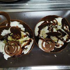 A picture of Chocolate cup with brownie and icecream on top.