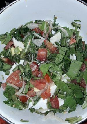 Una foto de Ensalada de rúcula, huevo, tomate y cebolla