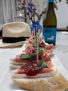 Una foto de Tapas con prosciutto brie y mermelada de fresa