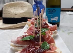 Una foto de Tapas con prosciutto brie y mermelada de fresa