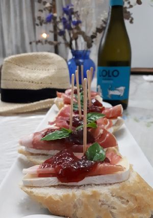 Una foto de Tapas con prosciutto brie y mermelada de fresa