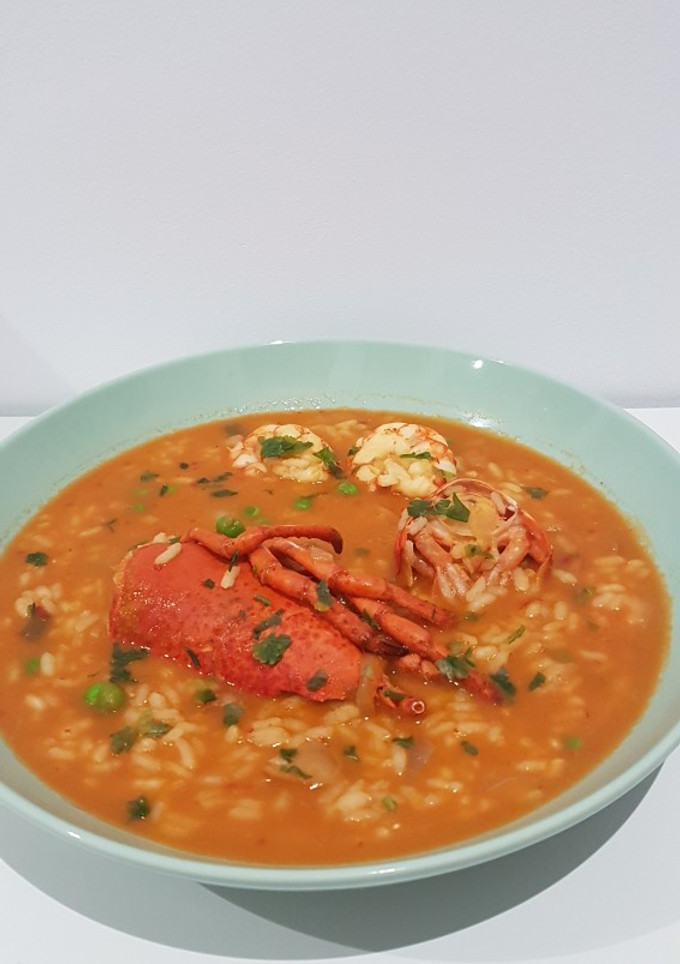 Una foto de Arroz caldoso con bogavante calamar y gambas