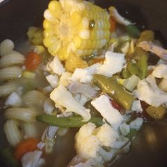 A picture of One Whole Chicken in a Soup over Noodles.