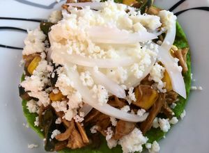 Una foto de Tostadas de pollo, rajas, elote y mole