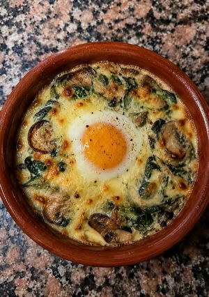 Una foto de Cazuelita Gratinada de Espinaca, Champiñones y Queso con Huevo al Horno 🥚🧀🍄